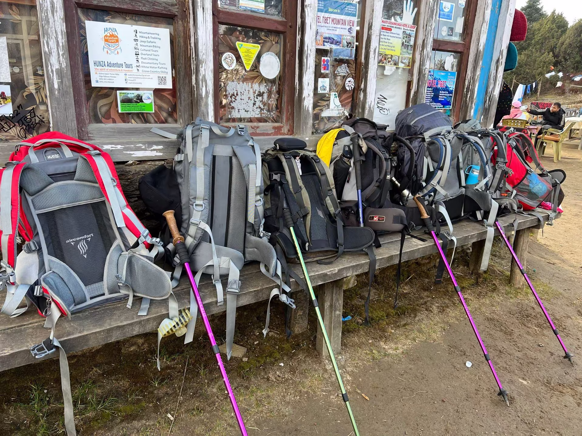 Trekking backpacks lined up on a long bench