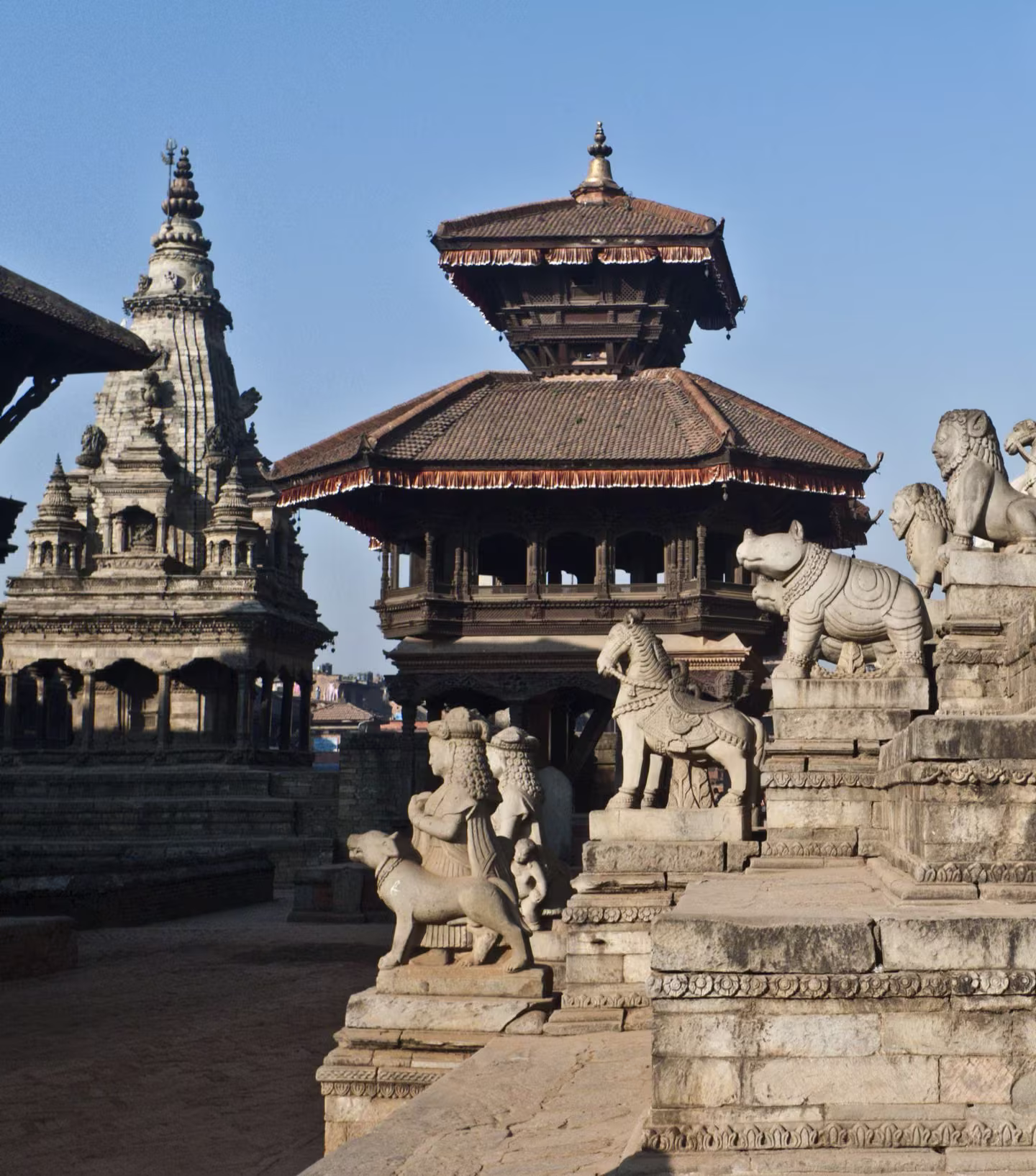 Stone guardian statues with Patan Durbar Square behind