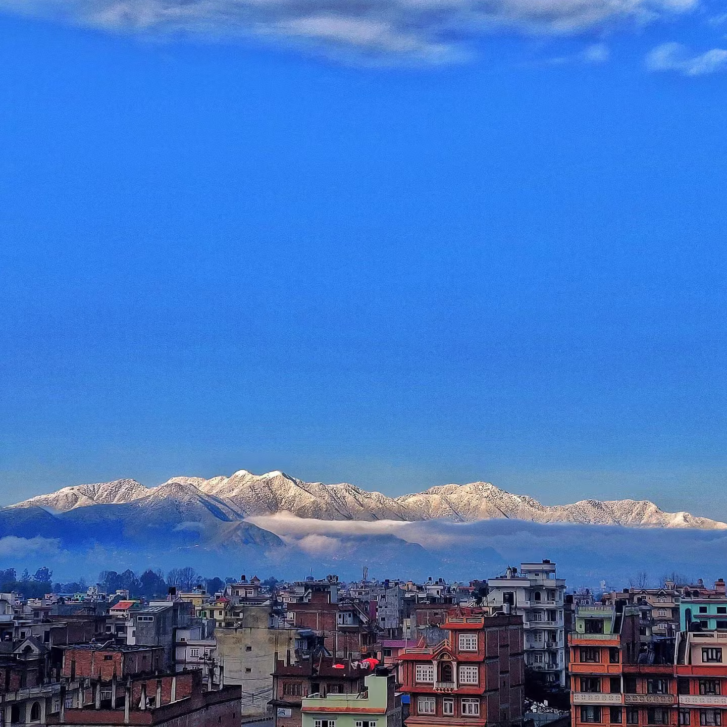 A Nepali city spread beneath a Himalayan mountain range