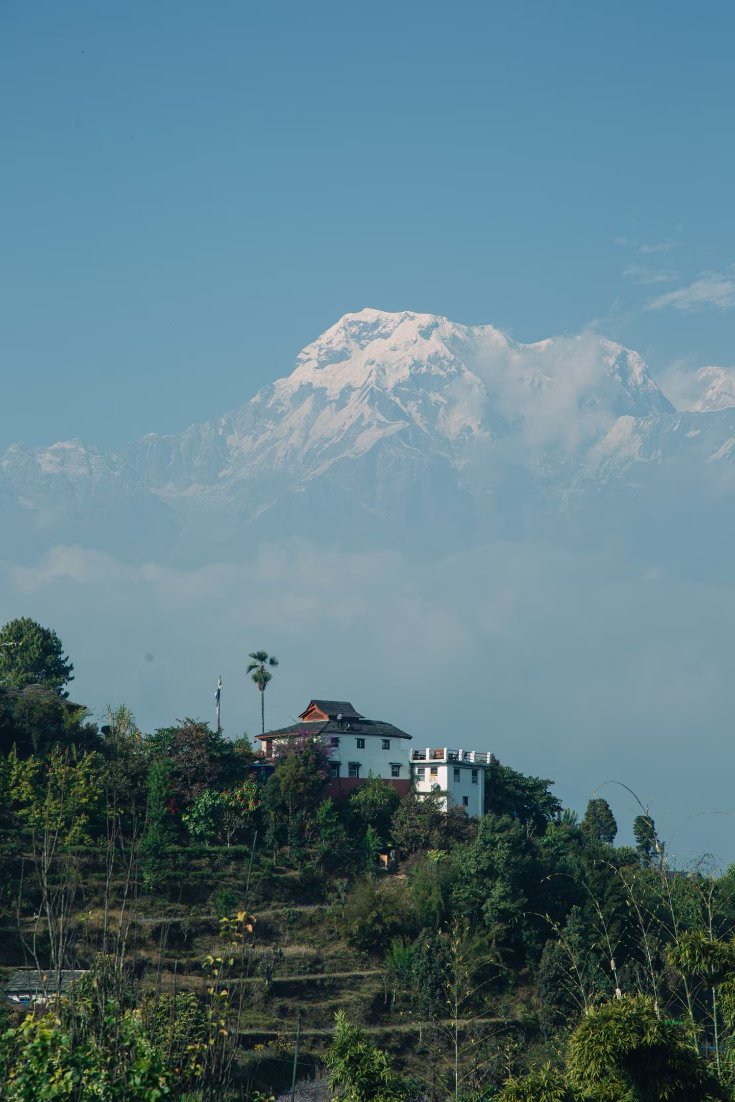 A lone stone house in the hills beneath a snowy peak