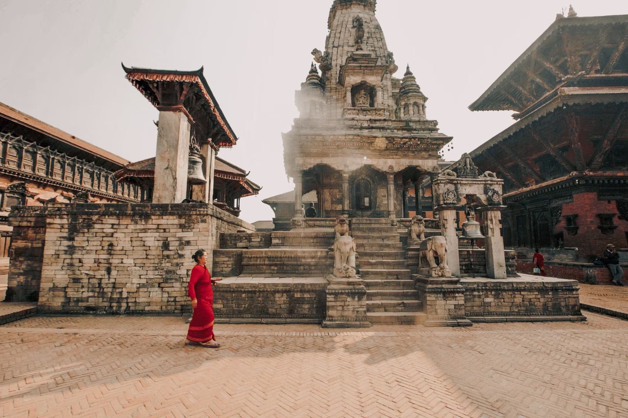 A woman walking in front of an old temple