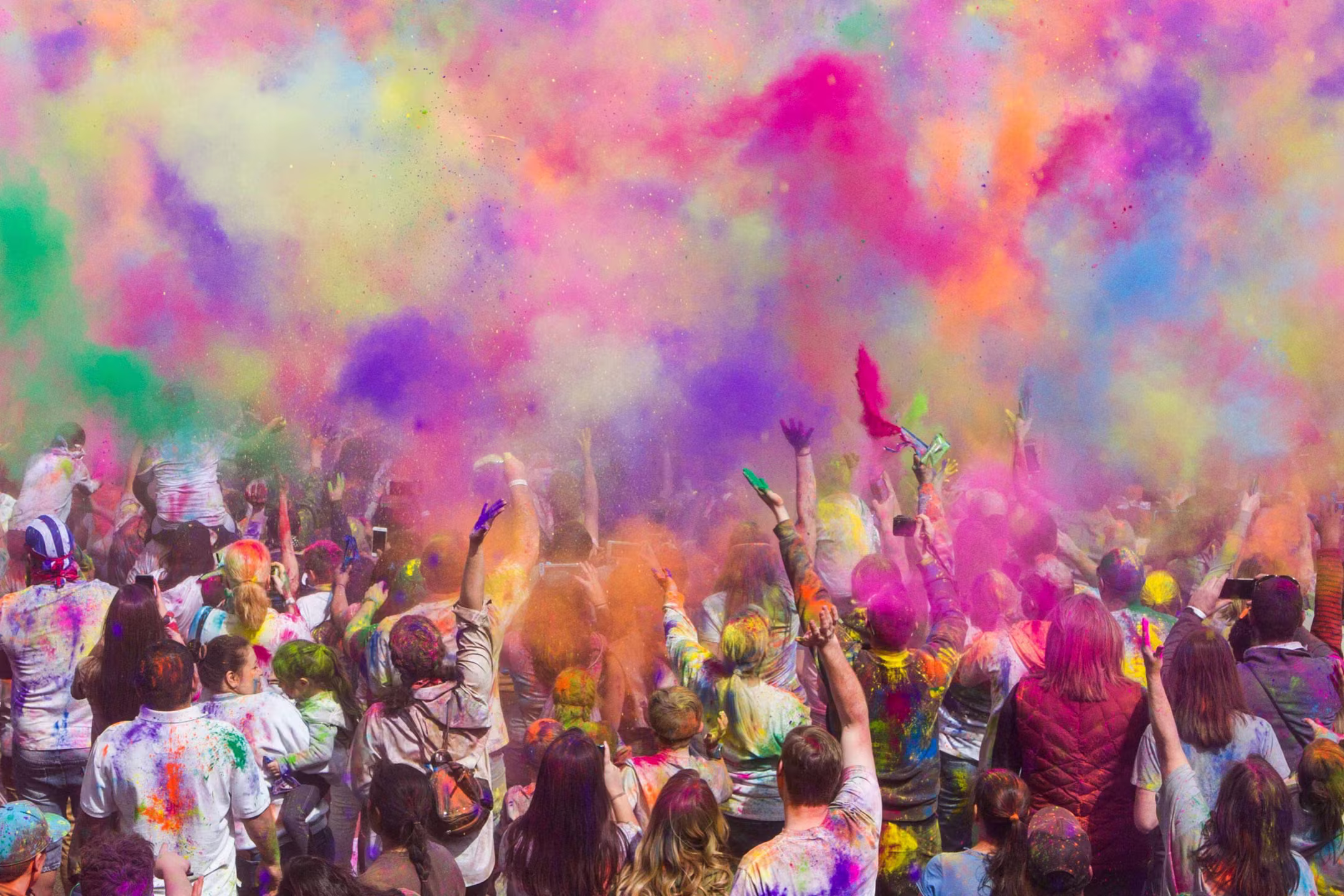 Crowds throwing color into the air during the Holi festival