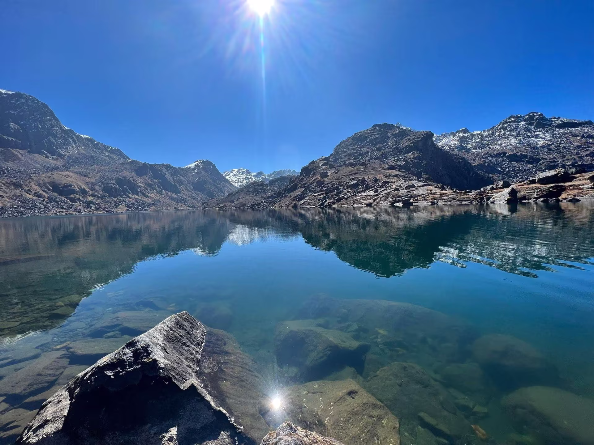 The still, clear blue water of Gosaikunda lake