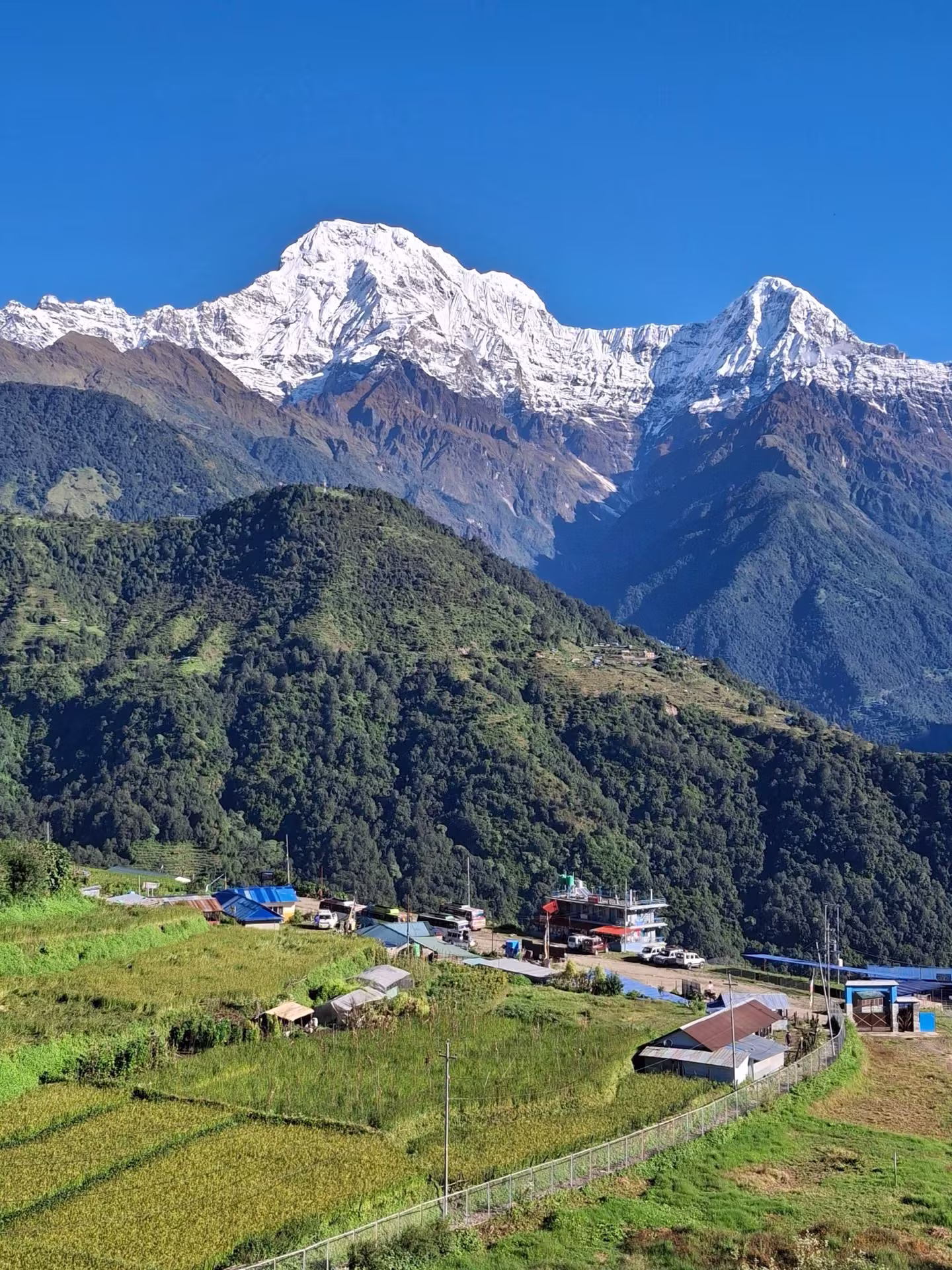 A hillside village with mountains rising behind it